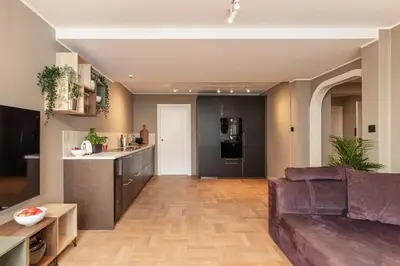 a living room with a couch and a kitchen at Nice apartment with stunning view over Bryggen in Bergen