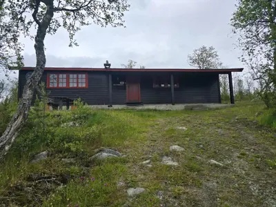 a house with a red door on a hill at Utsikten in Geilo