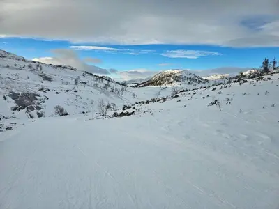 a snow covered slope with mountains in the background at Flott hytte i Elgtrakket 9, 3864 Rauland Skisenter - Holtardalen in Torvetjørn
