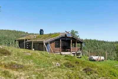 a house with a grass roof on top of a hill at Authentic Secluded Mountain Cabin in Telemark with Panoramic Views