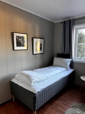 a bed in a bedroom with two pictures on the wall at Kikays Hygge in Bysheim