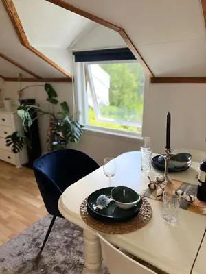 a dining room table with two chairs and a window at Studio in Os Near Bergen