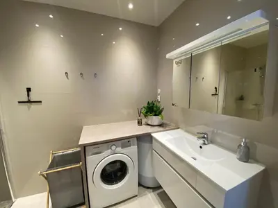 a bathroom with a washing machine and a sink at Spacious Modern Apartment City center in Bergen
