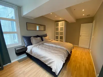 a bedroom with a large bed and a large window at Spacious Modern Apartment City center in Bergen