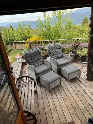 two chairs and a table on a wooden deck at Fantastic cabin in the woods & boat for rental or 2 days free boat on 7 days stay