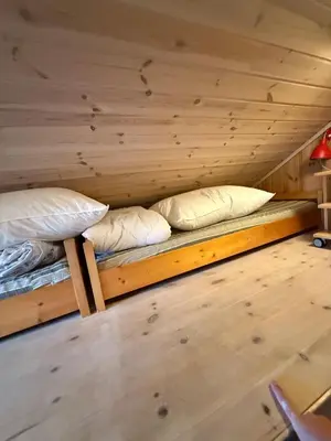 two bunk beds in a room with wooden walls at Fantastic cabin in the woods & boat for rental or 2 days free boat on 7 days stay