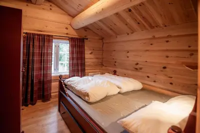 a bedroom with two beds in a log cabin at Trysilfjellet Sør 802 in Trysil