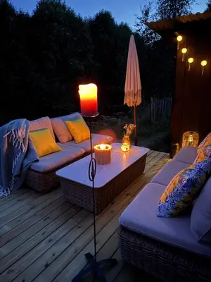 a patio with a couch and a table with a lamp at Gjestehus i Hurdal uten innlagt vann Delt bad in Hurdal