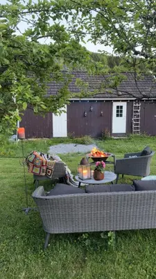 a couch sitting in the grass in a yard at Gjestehus i Hurdal uten innlagt vann Delt bad in Hurdal