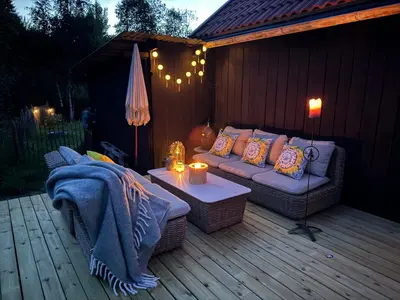 a patio with a couch and a table on a deck at Gjestehus i Hurdal uten innlagt vann Delt bad in Hurdal