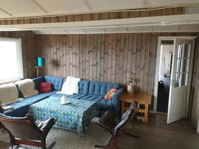 a living room with a blue couch and a table at Gullingen Cabin Winter Wonderland