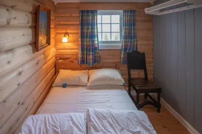 a small bedroom with a bed and a chair at Trysilfjellet Sør 480 in Trysil
