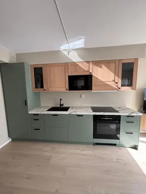 an empty kitchen with wooden cabinets and a sink at Leilighet i Bergen sentrum in Bergen