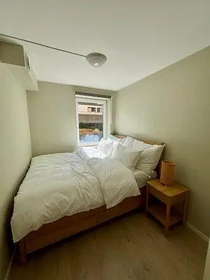 a bed with white sheets and a window in a room at Leilighet i Bergen sentrum in Bergen