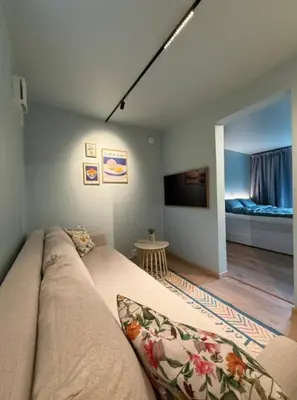 a living room with a couch and a bedroom at Moderne leilighet in Bergen