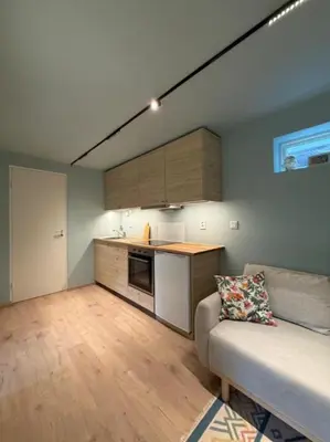 a living room with a couch and a kitchen at Moderne leilighet in Bergen
