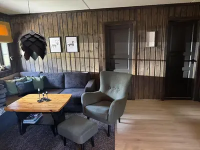 a living room with a blue couch and a table at Norefjell Ski in - Ski out in Noresund