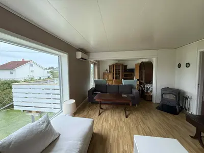 a living room with a couch and a fireplace at Et hus dypt i havet in Steinshamn