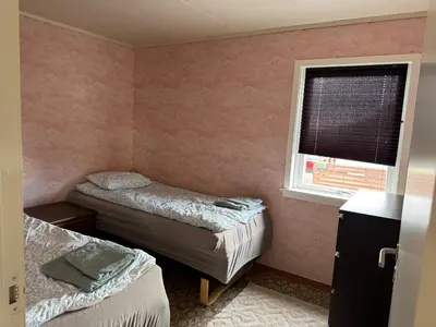 a small room with two beds and a window at Et hus dypt i havet in Steinshamn