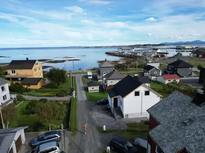 an aerial view of a town with a body of water at Et hus dypt i havet in Steinshamn