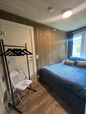a bedroom with a bed and a chair in it at Solsiden Geilo Cozy Studio location Geilo Centrum in Hol