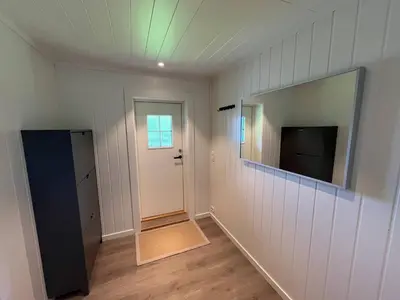 a room with a mirror and a door and a television at The simple appartment in Stryn in Stryn