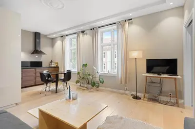 a living room with a table and a tv at Inviting & Cozy City Apartment in Bergen