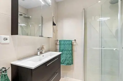 a bathroom with a sink and a glass shower at Inviting & Cozy City Apartment in Bergen