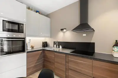 a kitchen with white appliances and wooden cabinets at Inviting & Cozy City Apartment in Bergen
