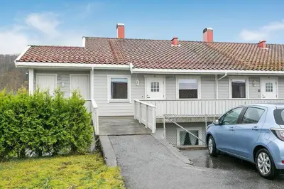 a blue car parked in front of a house at Central Langevåg Family Apartment in Sula