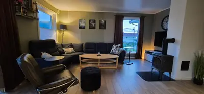 a living room with a couch and a table at Central Langevåg Family Apartment in Sula