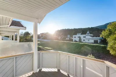 a balcony with a view of a house at Central Langevåg Family Apartment in Sula