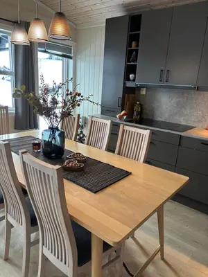 a kitchen with a wooden table with chairs and a dining room at Apartment vårstølen in Vossevangen