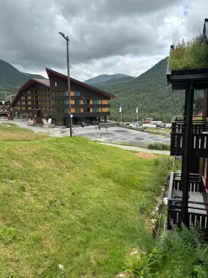 a large building with a grass field in front of it at Apartment vårstølen in Vossevangen