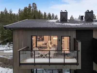 a house with a screened in porch in the snow at Motoppen Trysil Apartments in Trysil