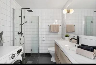 a bathroom with a shower and a toilet and a sink at Munkegata 30 Trondheim in Trondheim