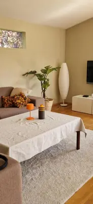a living room with a table and a couch at Hus ved sjøen, med strand og naust in Sauda