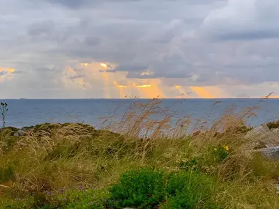 a view of the ocean with a rainbow in the sky at Drømmeplassen in Averoy