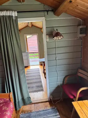 a small room with a door and a room with a table at Sjøbakken Fjord Camping AS in Sykkylven