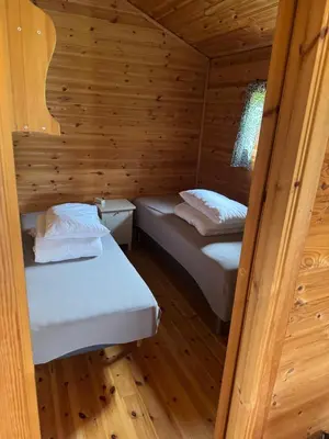 a room with two beds in a log cabin at Sjøbakken Fjord Camping AS in Sykkylven