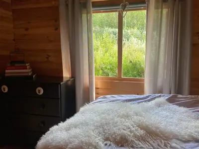 a bedroom with a bed with a window and a dresser at Hytte med panoramautsikt i Uvdal in Nørdstebø