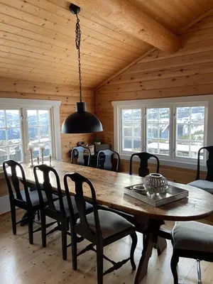 a dining room with a wooden table and chairs at Hytte med panoramautsikt i Uvdal in Nørdstebø