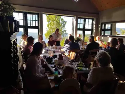 a group of people sitting at tables in a room at Villa Fjara sleeps 34 in Stange