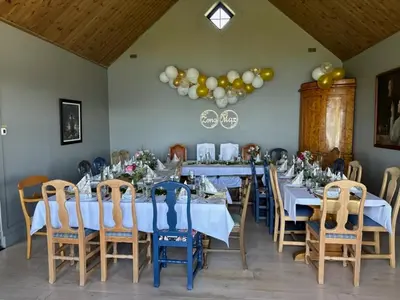 a dining room with blue tables and chairs and balloons at Villa Fjara sleeps 34 in Stange