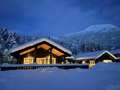 a log cabin in the snow at night at Fjellhytte sentralt og solrikt in Stryn