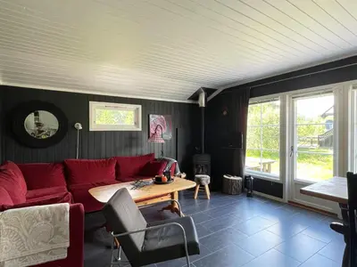 a living room with a red couch and a table at Revehiet - 3 bedroom cabin in the center of Geilo in Geilo