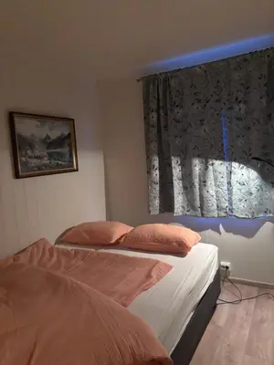 a bedroom with two beds and a window with a window treatment at Best flat in town in Kristiansund