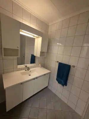 a bathroom with a sink and a blue towel at Best flat in town in Kristiansund