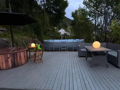 a patio with a table and chairs and an umbrella at Home with 5 bedrooms, great view and garden in Bergen