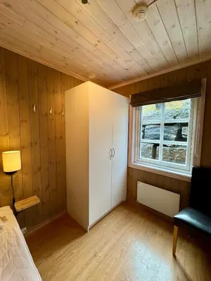 a bedroom with a white cabinet and a window at Fantastisk utsikt i Hemsedal med ski in og ski ut in Fausko